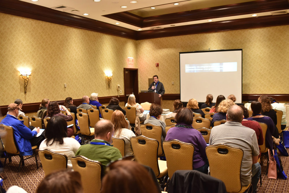 This image shows a room full of conference attendees at a session.